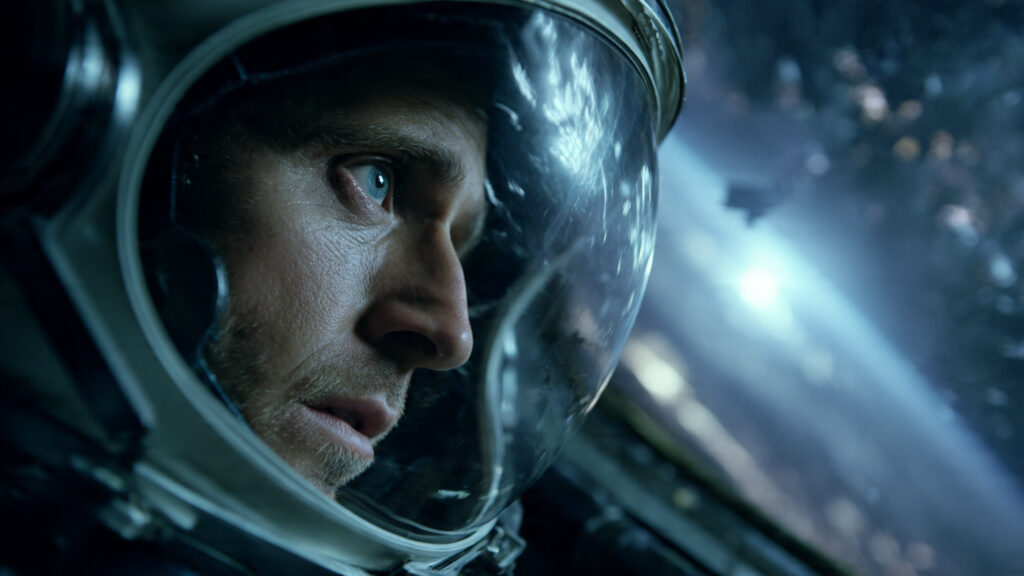 Beyond the Event Horizon: Best Sci-Fi Movies Like Interstellar's Grandeur 3 dramatic shot of Ryan Gosling as Ryland Grace in a spacesuit, looking determinedly out a spaceship window at a distant star.