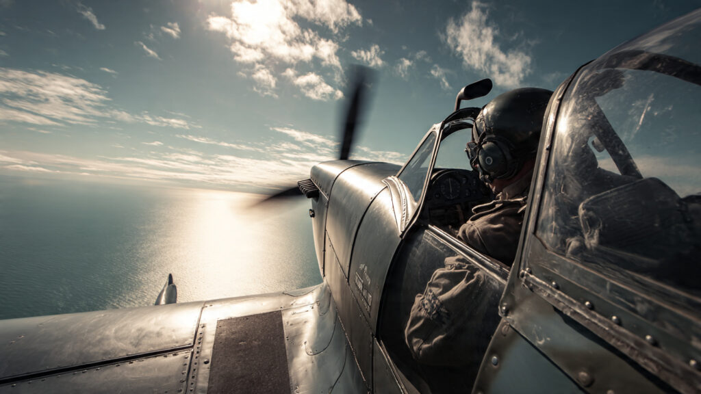  A Spitfire plane flying over the English Channel, pilot in the cockpit