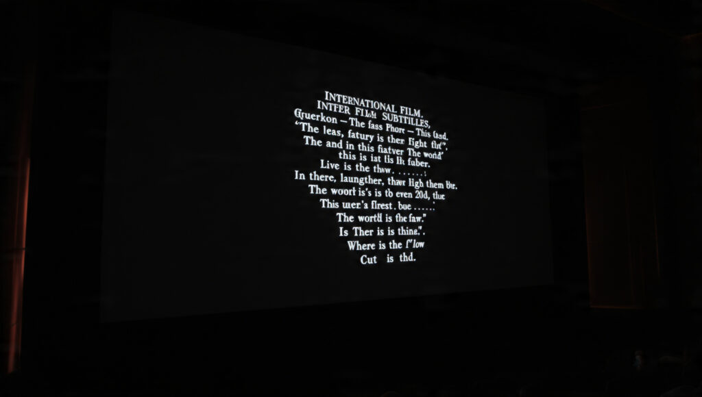 Cinema screen showing international film subtitles