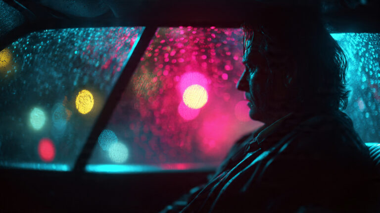 Cinematic shot in the style of Nicolas Winding Refn, a man sitting in a car at night under flickering pink and cyan neon lights, intense shadows, highly saturated colors, rainy windshield with bokeh light reflections, 8k, moody and atmospheric, synthwave aesthetic.