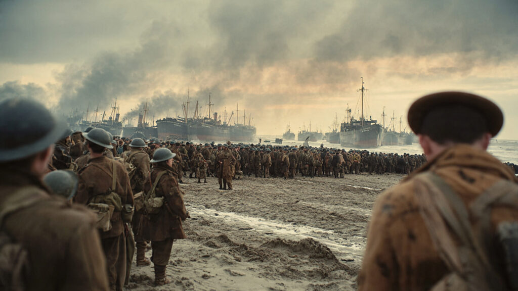 Soldiers waiting on the beach of Dunkirk with ships in the background during the evacuation